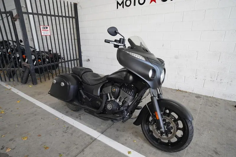 Black Indian Motorcycle with saddle bags parked at Moto United dealership, showcasing sleek design and powerful engine